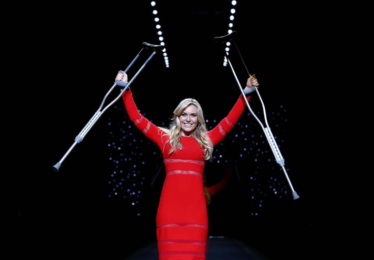 Image: Lindsey Vonn raises her crutches as she presents a creation by Cynthia Rowley for the The Heart Truth Fall 2014 collection during New York Fashion Week