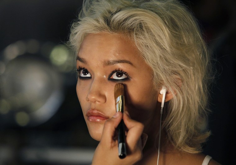 Image: A model has her make-up applied before presenting a creation by DKNY during New York Fashion Week