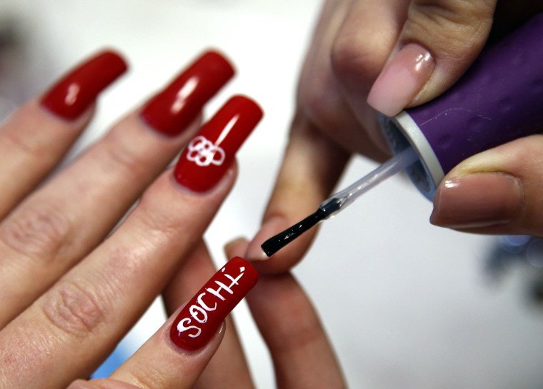 Image: Woman has her nails painted with the Olympic rings at beauty salon in Sochi