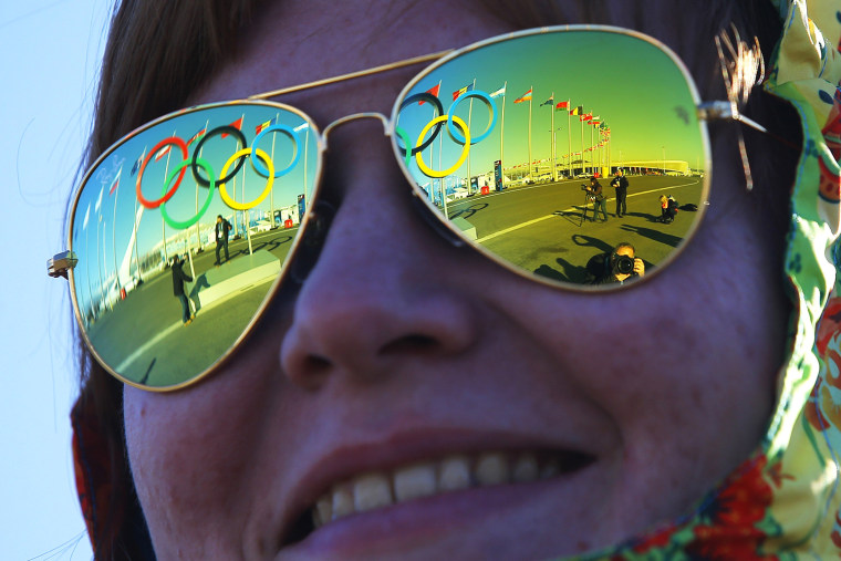Image: The Olympic rings are reflected in the sunglasses of a volunteer at the Olympic Park at the 2014 Sochi  Winter Olympic Games