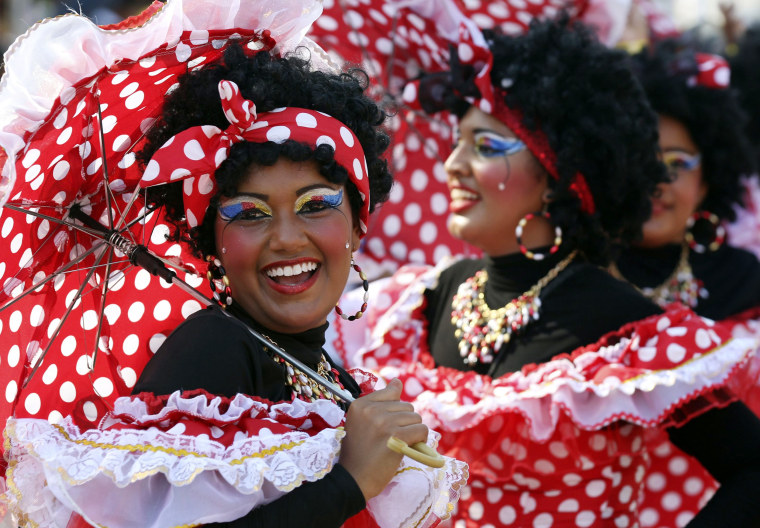 Image: Revellers dressed as \"Negritas Puloy\" perform during the \"Battles of the Flowers\" parade as part of carnival celebrations in Barranquilla