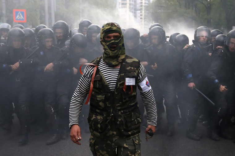 Image: A pro-Russian protester walks in front of riot police during a pro-Ukraine rally in the eastern city of Donetsk