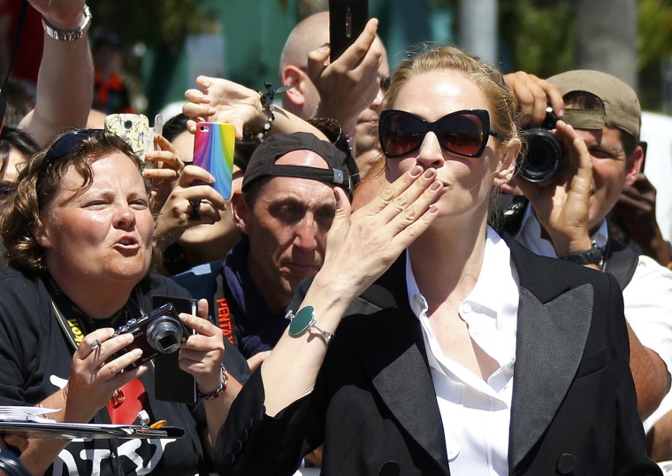 Image: Actress Uma Thurman blows a kiss after signing autographs on the Croisette during the 67th Cannes Film Festival in Cannes