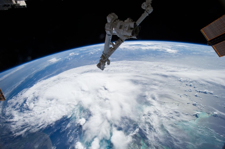 Looking out the window of the International Space Station in early July, astronauts spotted a sprawling mass of clouds. The clouds were just beginning to take shape as the first tropical storm of the 2014 season built over the Atlantic Ocean. Tropical Storm Arthur formed off southern Florida on July 1, 2014. By morning of July 2, when an astronaut took this photo with a wide-angle lens, the storm was moving north along the Florida coast. Surrounded by bright green waters, the Bahamas are south of the storm in the lower right corner of the photo. The U.S. coastline stretches along the left side of the photo.