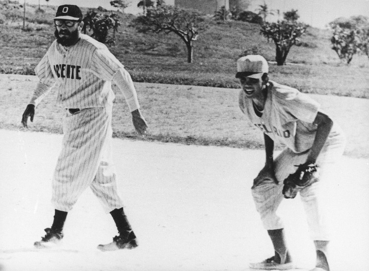 Cuban Prime Minister Fidel Castro, wearing the uniform of his favorite team Oriente, is seen as he takes lead off first base, during a baseball game at Varadero Beach, Cuba, on July 5, 1964. The premier hit two singles and drove in four runs in addition to pitching nine innings for the team of Camaguey Province. His team won 14:4 against the team of Pinar Del Rio. (AP Photo)