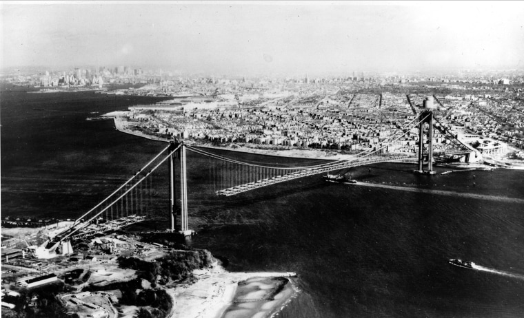 This aerial view shows New York's Verrazano-Narrows Bridge suspension span under construction with the steel roadway nearing completion in March 1964.  The bridge, located at the mouth of upper New York Bay, will connect Staten Island with Brooklyn.  The Staten Island tower is in foreground.  (AP Photo)