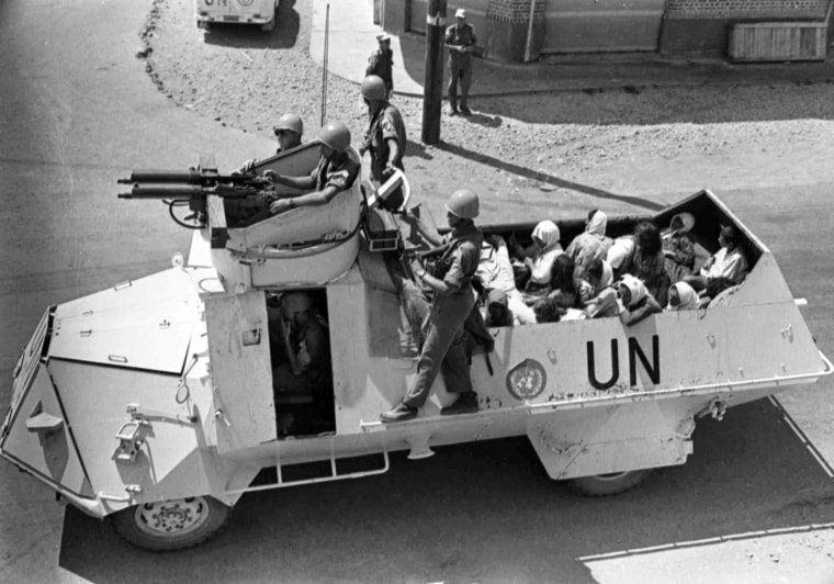 United Nations carry Turkish Cypriot women and children in the back of their armoured carrier for a trip from their village of Kokkina to safety in Lefka, on Sug. 9, 1964, due to heavy fighting in the area. (AP Photo/Str/Koundakjian)