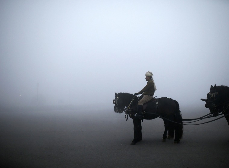 Image: Indian PBG mounted on his horse, takes part in a rehearsal for the Republic Day parade on a foggy winter morning in New Delhi