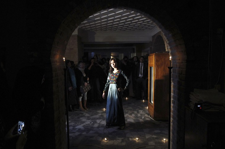Image: A model presents an Afghan traditional dress at a fashion show, launched by Young Women for Change, in Kabul