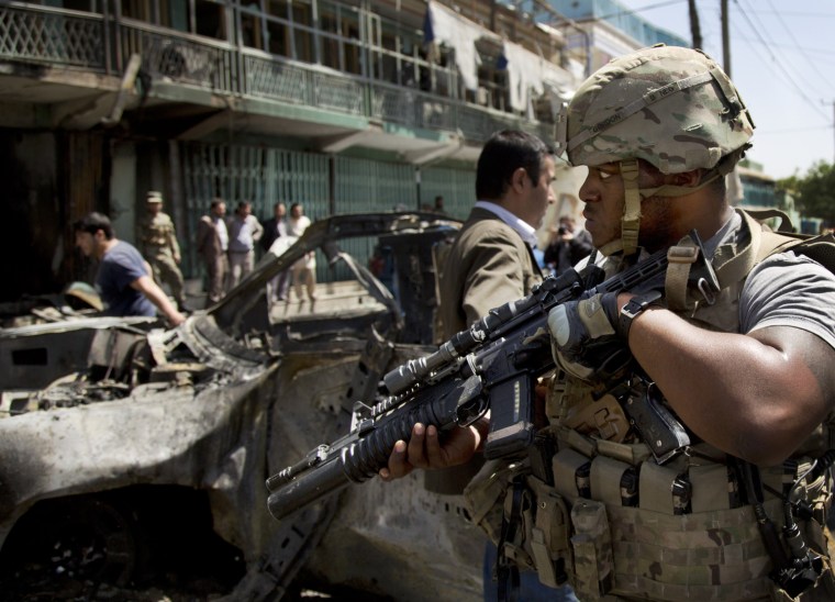Image: A U.S. soldier arrives to the scene where a suicide car bomber attacked a NATO convoy in Kabul, Afghanistan.