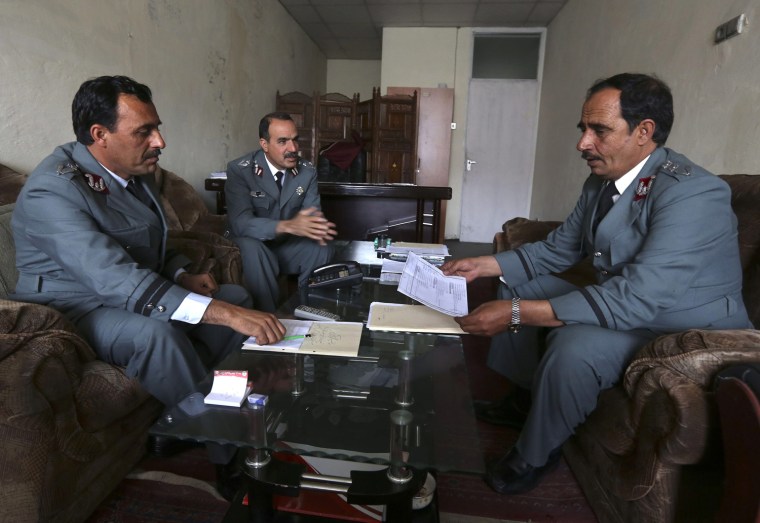 Image: Police officers from anti-corruption Shafafiyat unit work on documents at their office in Kabul