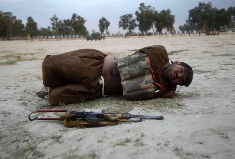 Image: A suicide attacker lies on the ground after his vest was defused in Jalalabad province