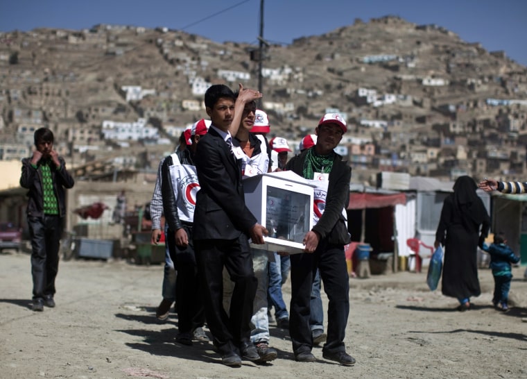 Image: Volunteers from the Afghan Red Crescent Society carry a donation box for victims of last week's Japan earthquake and tsunami, on the streets of Kabul