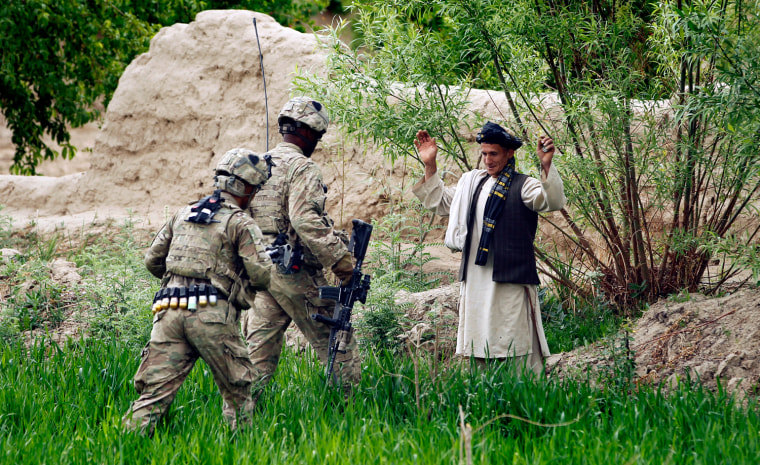 Image: U.S. Army soldiers approach a local man for questioning during a patrol near the village of Sai'dano Kalache in the Arghandab Valley north of Kandahar