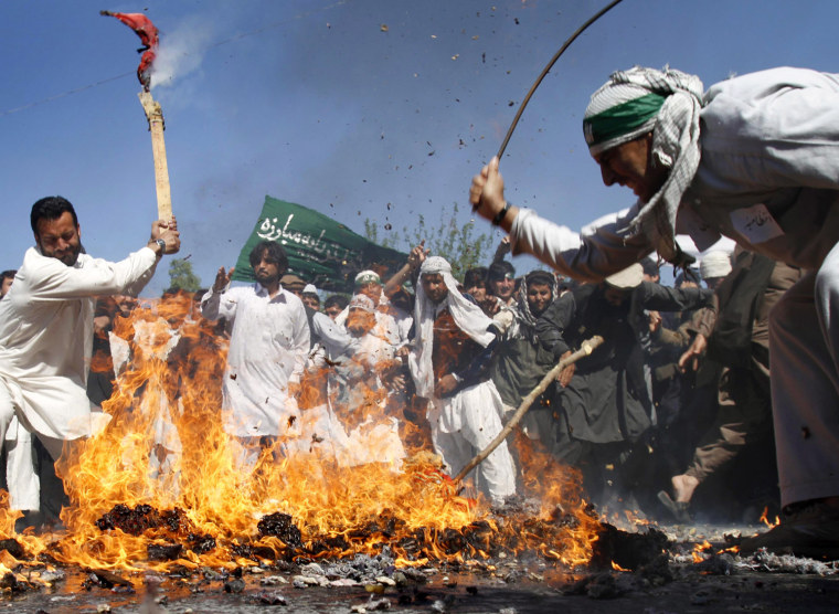 Image: Afghan protestors beat a burning effigy of U.S. President Barack Obama during a demonstration in Jalalabad, Afghanistan on Sunday.