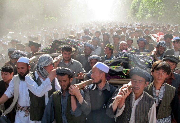 Image: Afghans carry the bodies of people killed overnight after a raid by NATO and Afghan forces, during a protest in Taloqan