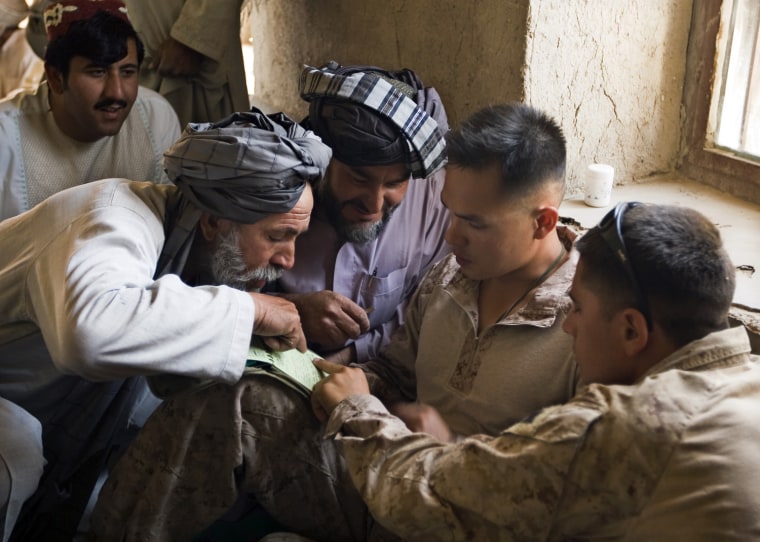 Image: Elders from the Alizai tribe discuss a project with a U.S. Marines Sergeant during a Shura meeting outside Camp Gorgak in Helmand province