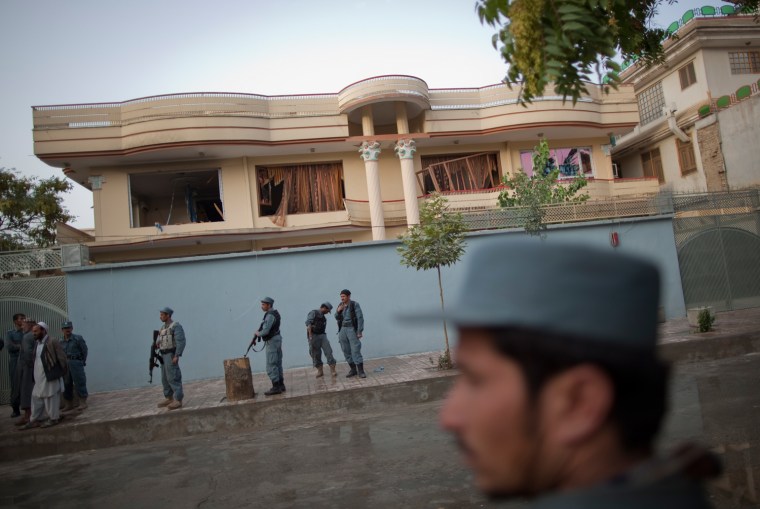 Image: Afghan police keep watch outside the house of Khan, who was killed by armed gunmen during Sunday's attack, in Kabul