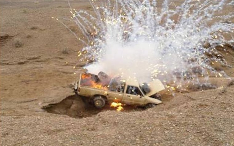 Image: A car is destroyed by U.S. Marines after being detected trafficking drugs by a Royal Navy Sea King Mk 7 surveillance helicopter in Helmand province
