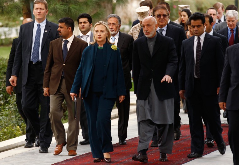 Image: U.S. Secretary of State Hillary Clinton walks with Afghan President Hamid Karzai at the Presidential Palace in Kabul