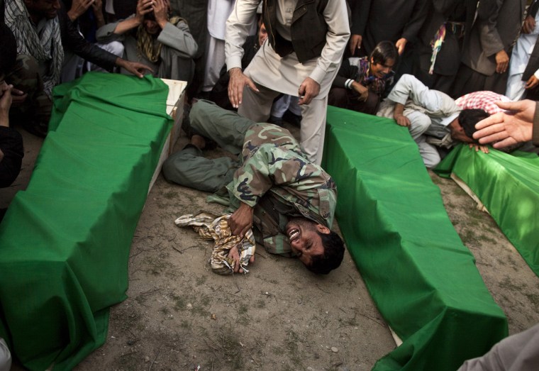 Image: A man mourns the death of his brother, who was killed in a fuel tanker blast, in Parwan province