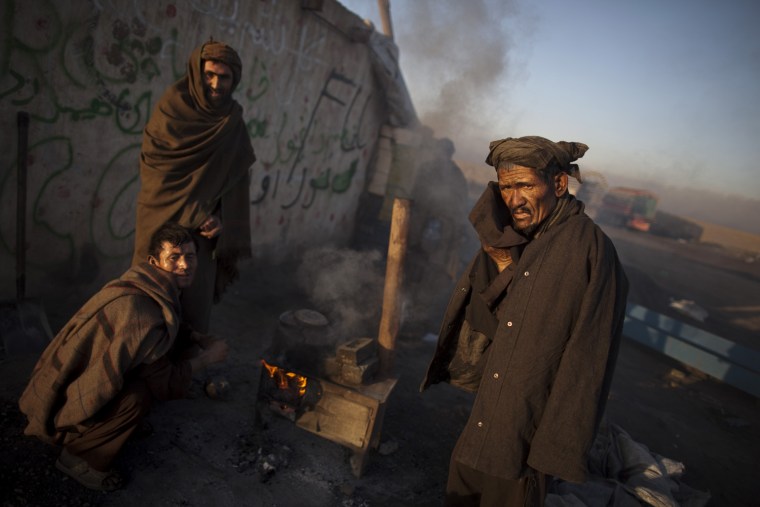 Image: Labourer cleans his face after washing in the early morning hours outside Kabul