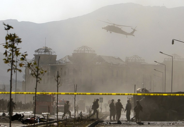 Image: A NATO helicopter flies over the site of a bomb blast in Kabul