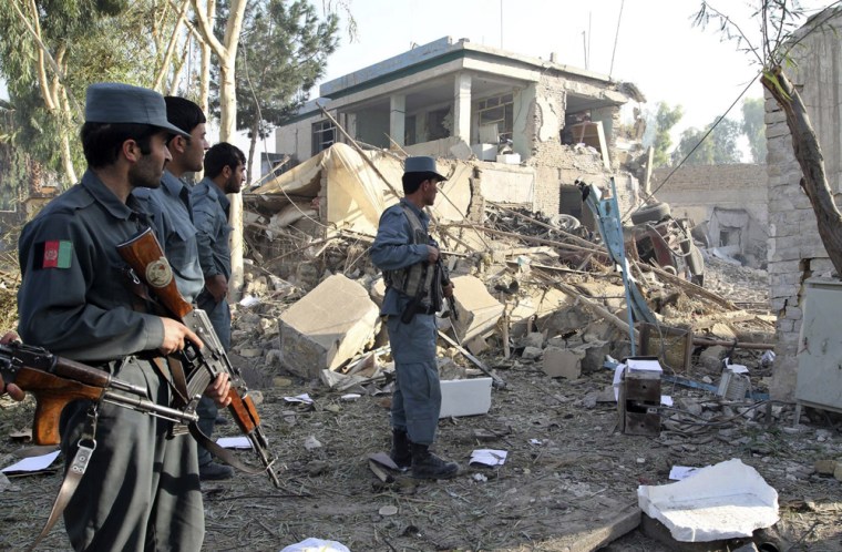 Image: Afghan policemen keep watch after a suicide bomb attack near a building used by the Office of the United Nations High Commissioner for Refugees (UNHCR) in Kandahar