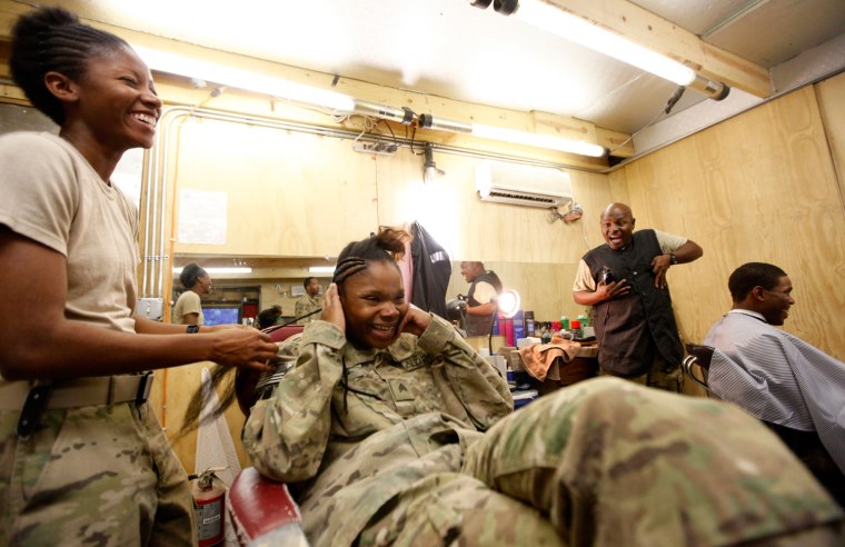Image: U.S. Army soldiers of A Company 125 BSB 3/1AD Task Force Mustang chat as they get hair cuts at Forward Operating Base Shank in Logar province