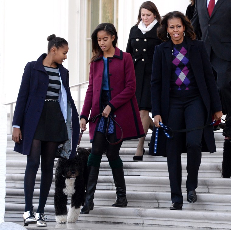 Image: US First Lady Michelle Obama hosts a ceremony to welcome the official White House Christmas Tree with daughters Malia and Sasha and the First Family's dogs Bo and Sunny
