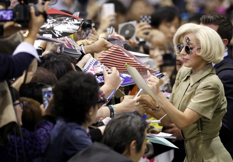Image: Lady Gaga signs autographs for fans upon her arrival at Narita international airport
