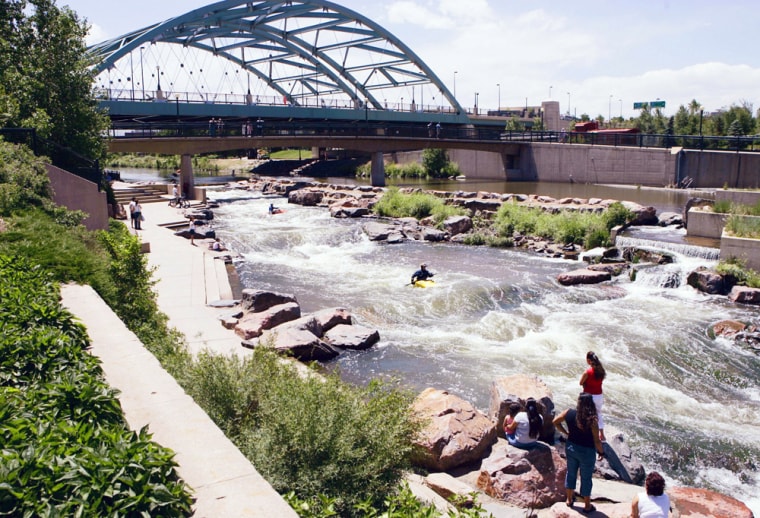 ** FILE**  In this June 8, 2005 file photo park goers watch from the banks of the Platte River at Confluence Park in Denver as a couple of kayakers make their way through the white water. Denver has more than 200 parks, rivers and trail areas, public golf courses and recreation centers. (AP Photo/Ed Andrieski, File)