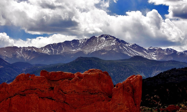** FILE** In this May 2, 2006 file photo the sun breaks through the clouds to highlight the summit of Pikes Peak as seen from the Garden of the Gods in Colorado Springs, Colo. (AP Photo/Ed Andrieski, File)