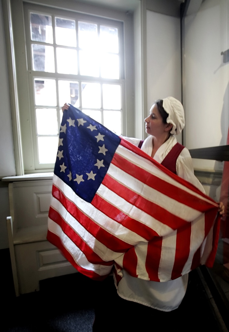 **FILE** In this June 6, 2006 file photo, Cyndi Janzen playing the part of Betsy Ross displays a United States flag at the Betsy Ross House in Philadelphia. (AP Photo/Matt Rourke, File)