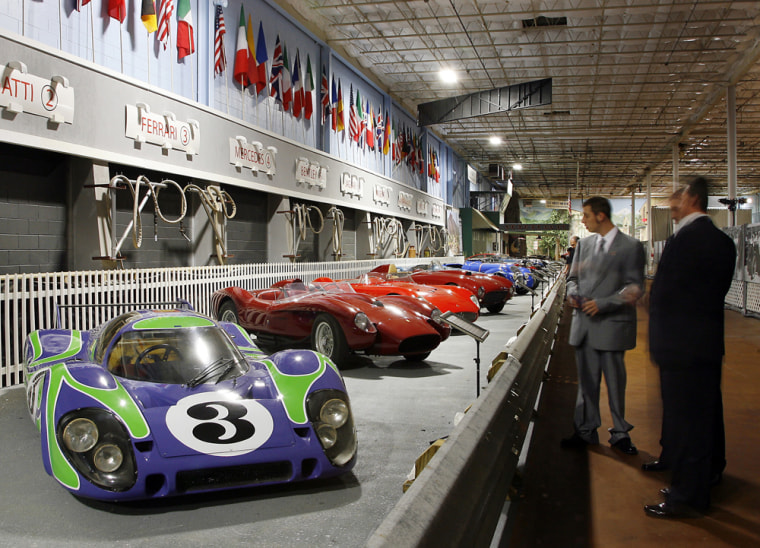 Visitors admire a Porsche 917, left, on display in the \"pit road\" section at the Simeone Foundation Automotive Museum, Wednesday, Nov. 12, 2008 in Philadelphia. (AP Photo/Tom Mihalek)