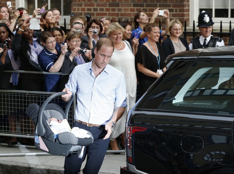Image: Britain's Prince William carries his son the Prince of Cambridge into a car outside St. Mary's Hospital.