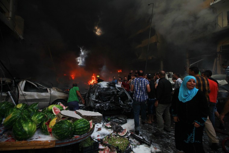 Image: A woman cries at the site of an explosion in Beirut's southern suburbs
