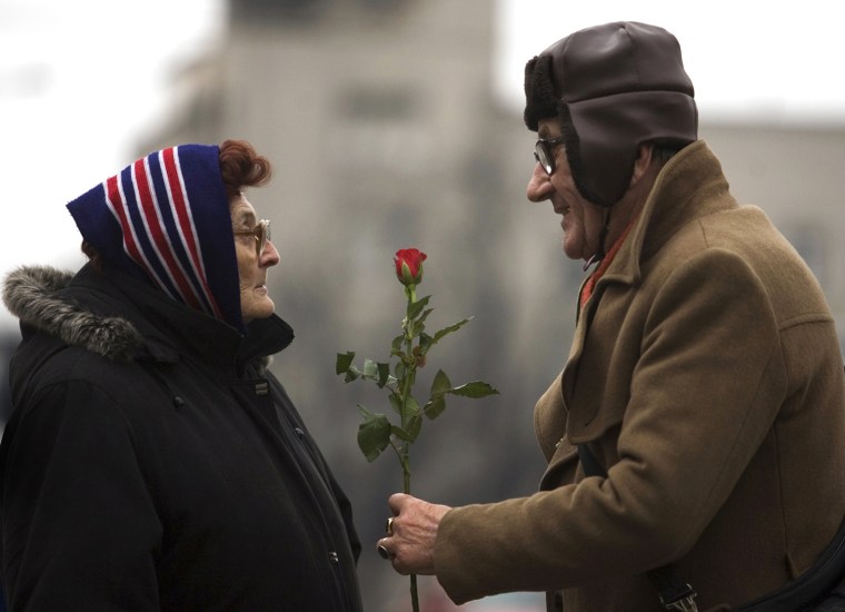 Image: A man offers a rose to a woman to mark International Women's Day in Belgrade
