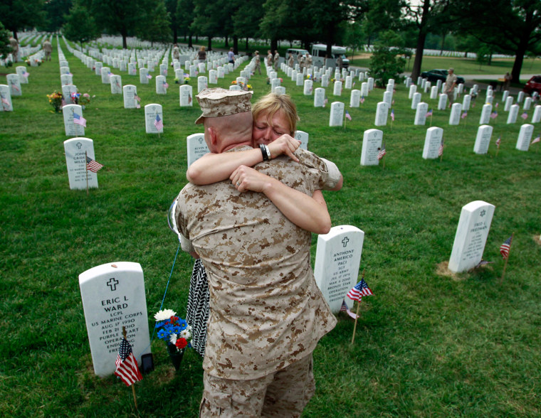 Image: Monica McNeal hugs a U.S. Marine at the gravesite of her son Eric Ward at Arlington National Cemetery in Virginia