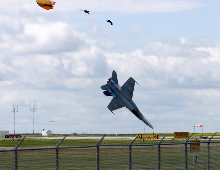 Image: Pilot Capt. Brian Bews parachutes to safety as his a CF-18 fighter jet plummets to the ground during a practice flight