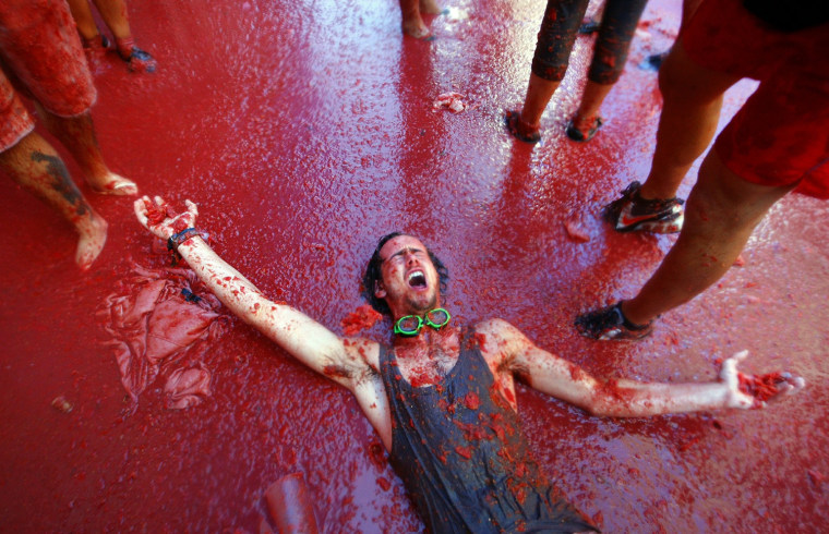 Image: 

A man is pelted with tomatoes during the \"Tomatina\" Festival