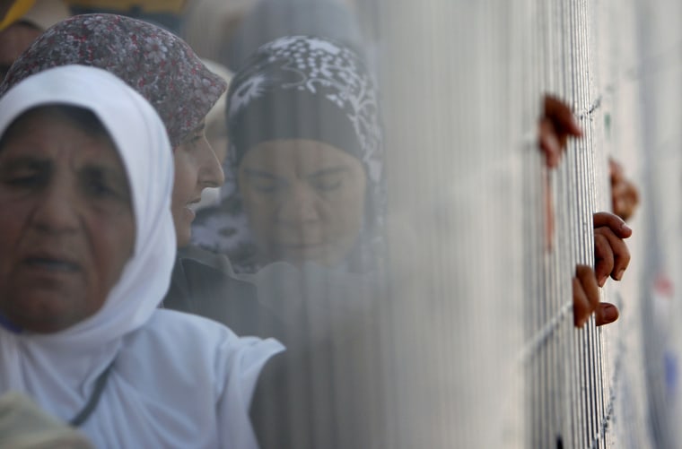 Image: Palestinian women wait in line to cross towards Jerusalem through Israel's Qalandiya checkpoint near the West Bank city of Ramallah