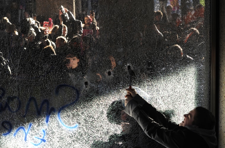 Image: Demonstrators break windows of the Conservative Party headquarters building during a protest in central London