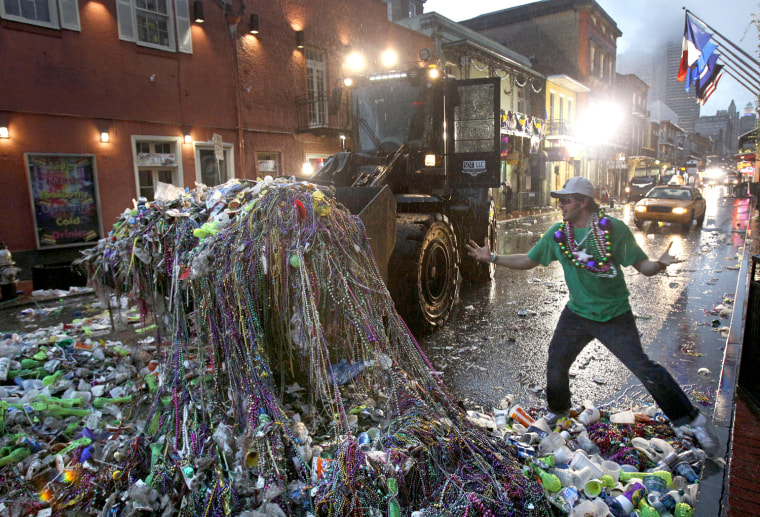 Image: Mardi Gras reveler Mike Turpin, whose night still isn't over, reacts as a front loader collects beads and other debris left behind by revelers on Bourbon Street in the French Quarter of New Orleans