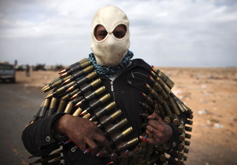 Image: A Libyan volunteer carries ammunition on the outskirts of the eastern town of Ras Lanouf, Libya,