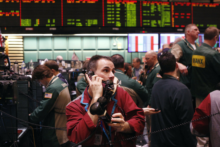 Image: A trader works with three telephone receivers in the crude oil and natural gas options pit on the floor of the New York Mercantile Exchange