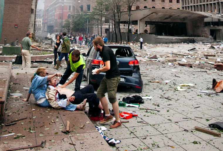 Image: An injured man is attended to at the site of a powerful explosion that rocked central Oslo