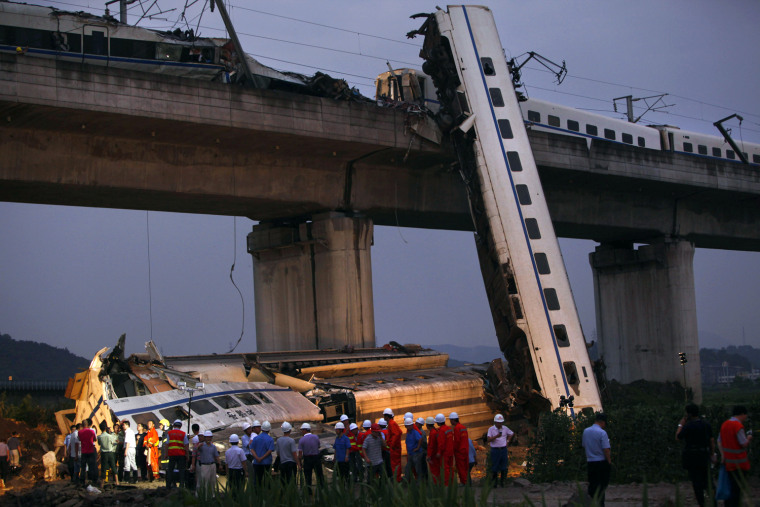 Image: Rescuers carry out rescue operations after two carriages from a bullet train derailed and fell off a bridge in Wenzhou, Zhejiang province