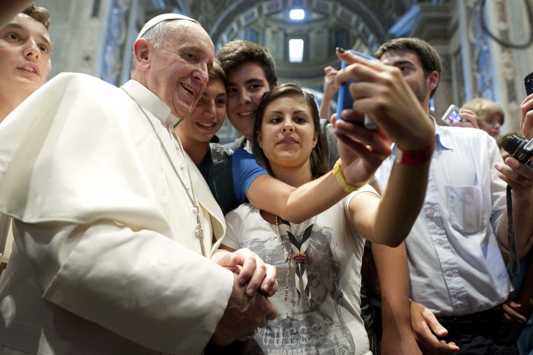 Image: Pope Francis poses with youths during a meeting with the Piacenza diocese in Saint Peter's Basilica at the Vatican