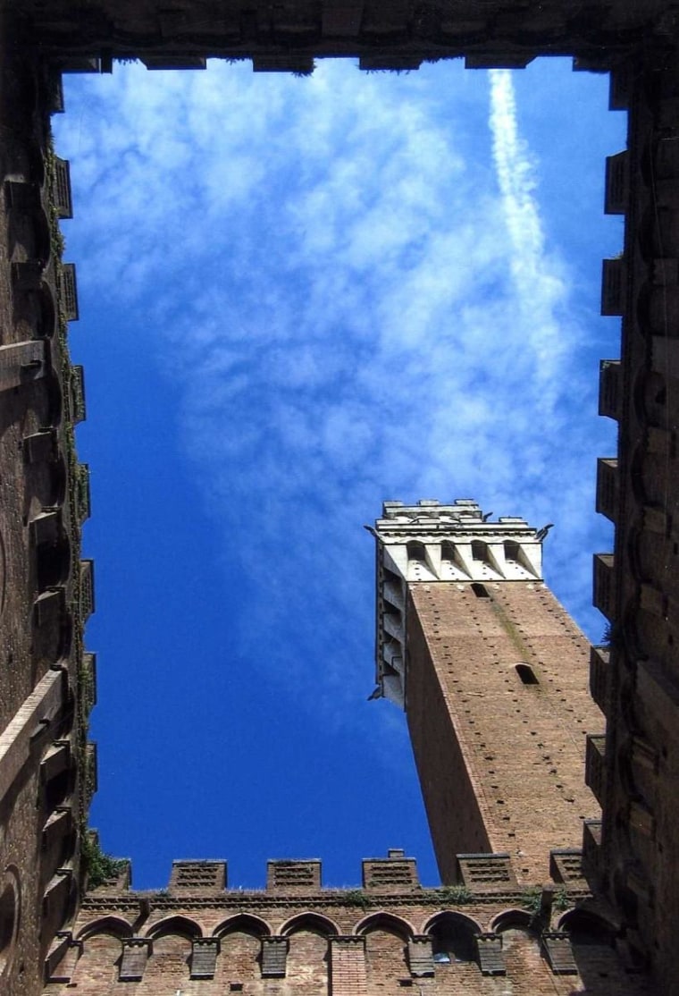 The beautiful, blue skies of Siena, Italy were interrupted as a plane flew over the Torre del Mangia.  After capturing the smoke trail, I followed the booming sound of drums into the sprawling Piazza del Campo, where the neighborhood parade  had begun for the drawing for the Siena Palio festival.  It was an unexpected traveling treat, as the parade had flag bearers, drummers and an ensemble of spectators all cheering and waving as the parade marched past.